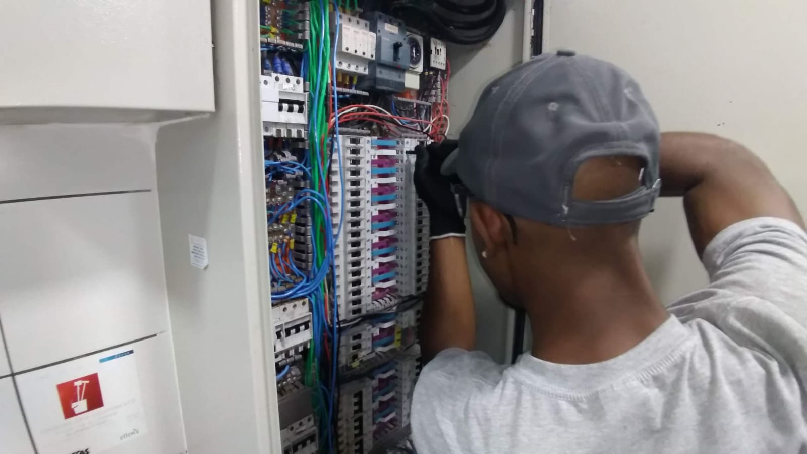 Técnico executando manutenção elétrica em condomínio